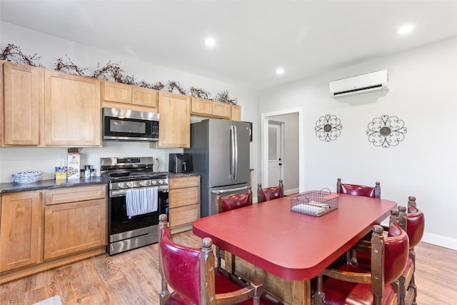 kitchen featuring a wall mounted air conditioner, stainless steel appliances, light wood-style floors, light brown cabinetry, and dark countertops