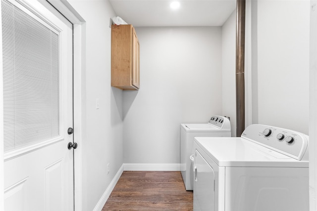 washroom featuring separate washer and dryer, dark wood finished floors, cabinet space, and baseboards