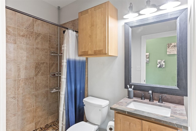 bathroom featuring tiled shower, vanity, and toilet