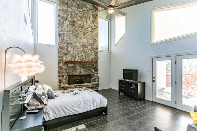 bedroom featuring a stone fireplace, multiple windows, and visible vents