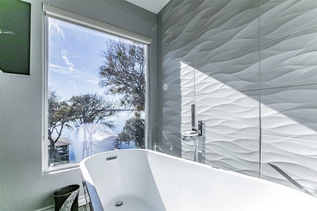 full bath featuring a stall shower, a soaking tub, visible vents, and a sink