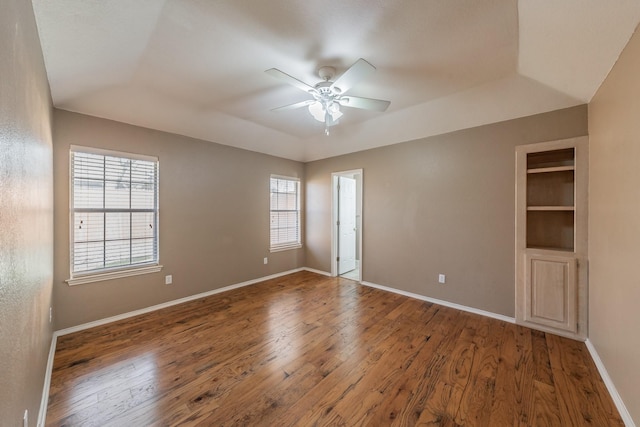 spare room featuring ceiling fan, hardwood / wood-style floors, and baseboards