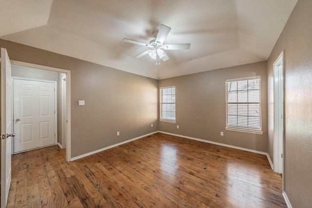 spare room featuring ceiling fan, baseboards, and wood finished floors