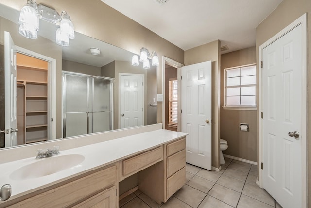 bathroom with tile patterned flooring, toilet, vanity, baseboards, and a stall shower