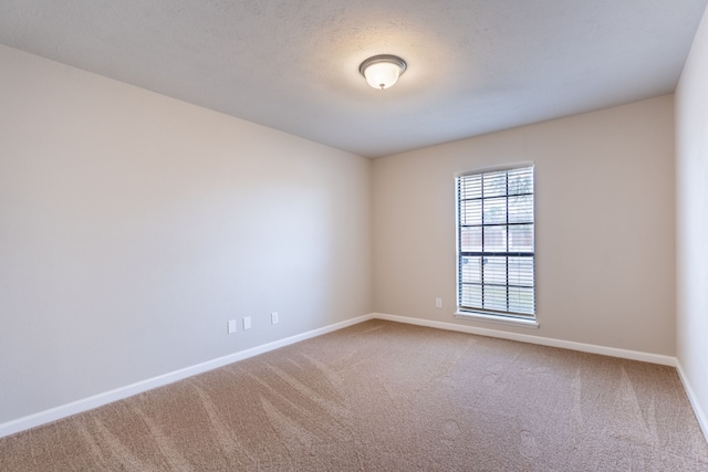 carpeted empty room featuring baseboards