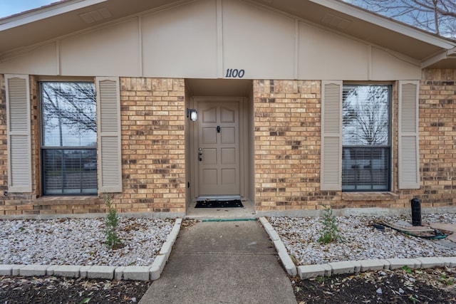 doorway to property with brick siding