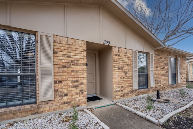 doorway to property featuring brick siding