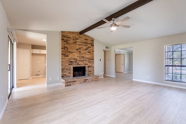 unfurnished living room featuring a fireplace, lofted ceiling with beams, light wood-style floors, a ceiling fan, and baseboards