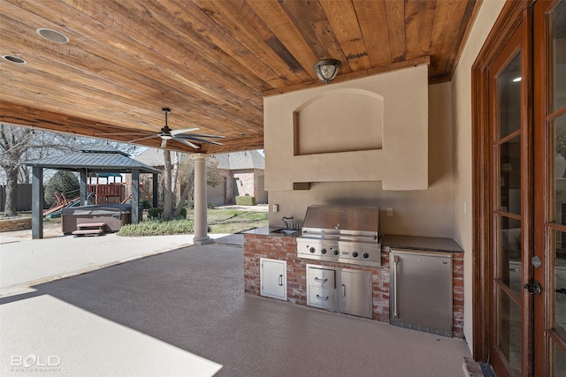 view of patio featuring french doors, grilling area, a gazebo, a ceiling fan, and exterior kitchen