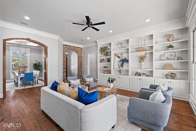 living area with arched walkways, recessed lighting, visible vents, ornamental molding, and hardwood / wood-style flooring