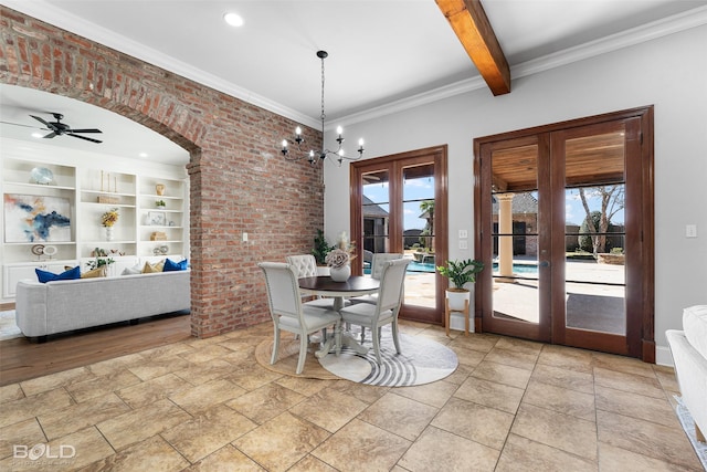 dining area featuring arched walkways, built in shelves, french doors, beam ceiling, and crown molding