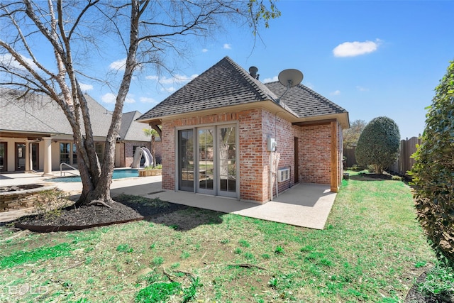 back of property featuring a patio, brick siding, a lawn, and french doors