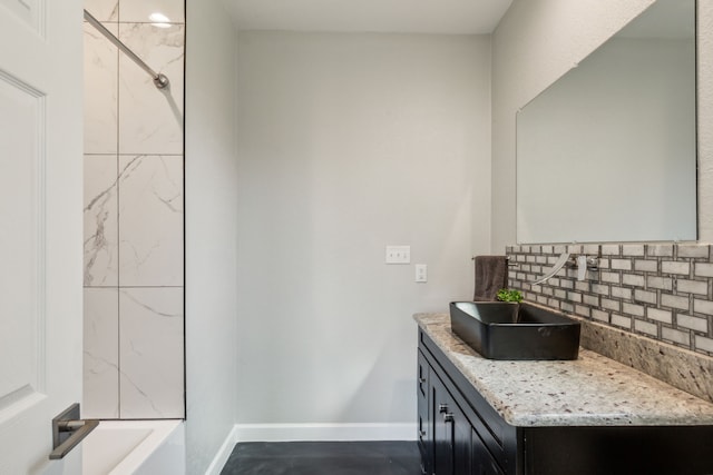 full bath with decorative backsplash, vanity, and baseboards