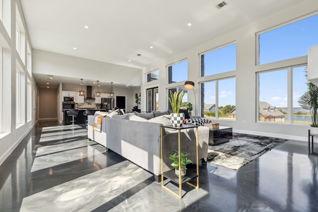 living room with recessed lighting, a towering ceiling, visible vents, and baseboards