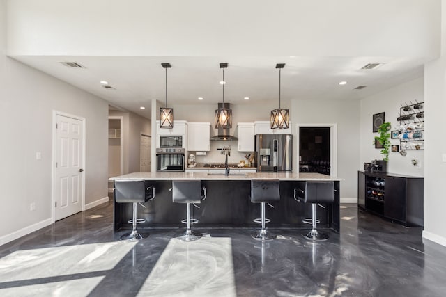 kitchen featuring wall oven, visible vents, white cabinetry, and stainless steel refrigerator with ice dispenser