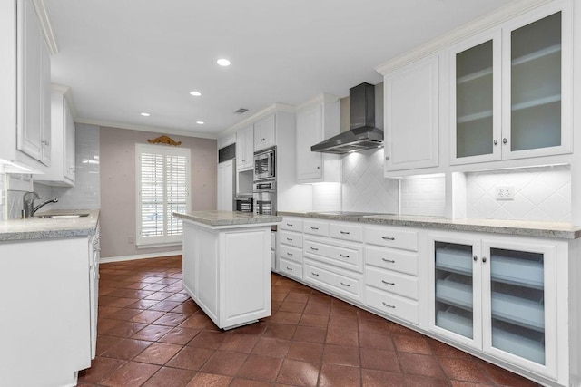 kitchen with white cabinets, wall chimney exhaust hood, stainless steel appliances, and a sink