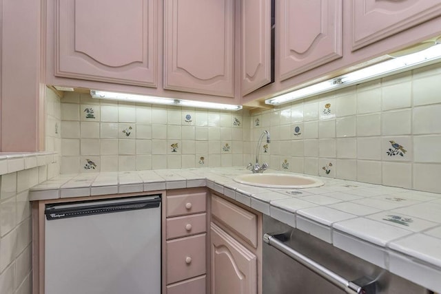 kitchen featuring a sink, tile counters, backsplash, and dishwasher