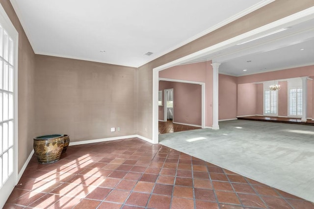 carpeted spare room with ornamental molding, tile patterned flooring, ornate columns, and an inviting chandelier