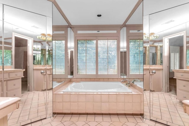 bathroom with tile patterned flooring, vanity, and a bath