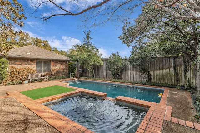 view of pool featuring a fenced backyard and a pool with connected hot tub