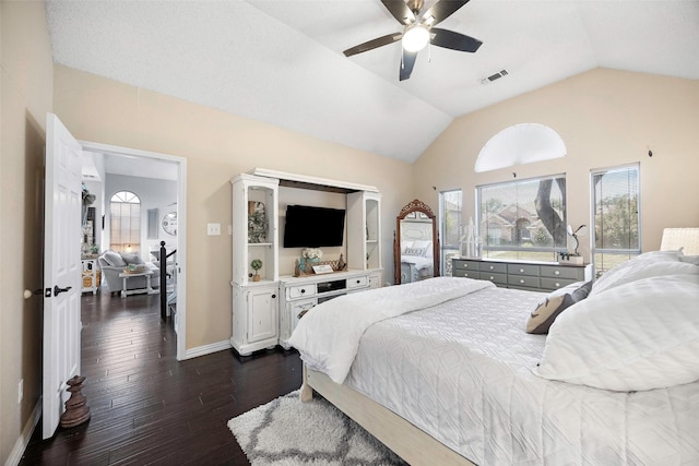 bedroom featuring dark wood finished floors, visible vents, a ceiling fan, vaulted ceiling, and baseboards