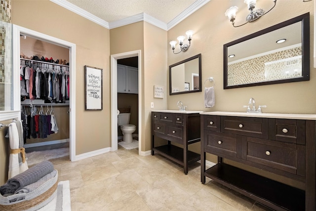 bathroom with ornamental molding, vanity, toilet, and a spacious closet