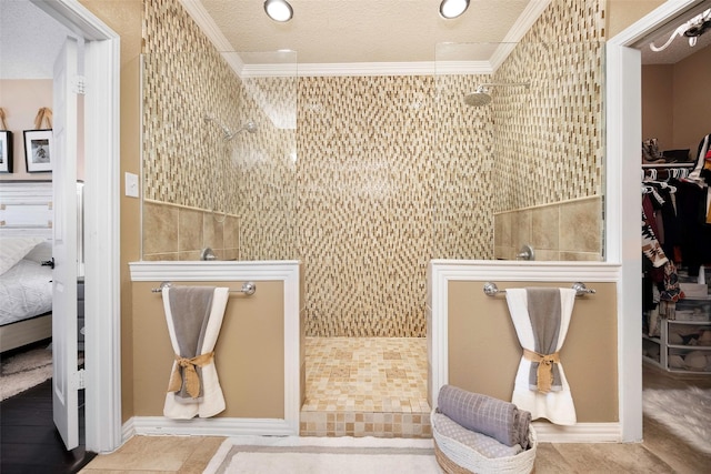 bathroom featuring a textured ceiling, ornamental molding, walk in shower, and connected bathroom