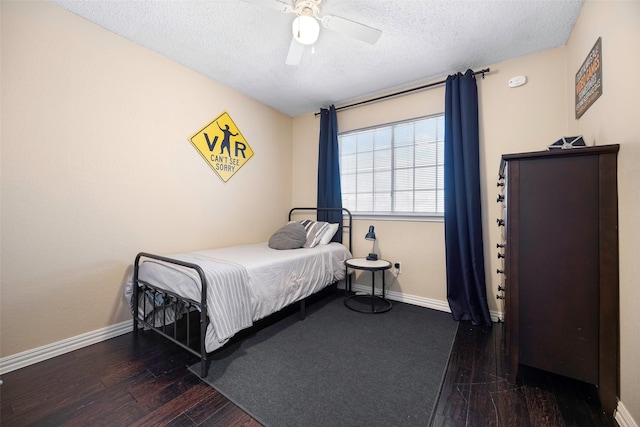 bedroom featuring a ceiling fan, a textured ceiling, baseboards, and wood finished floors