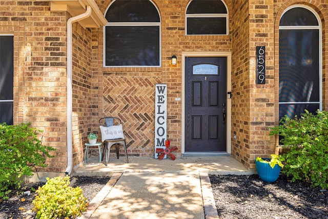 doorway to property with brick siding