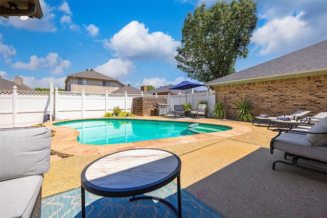 view of swimming pool with a patio area, a pool with connected hot tub, and a fenced backyard