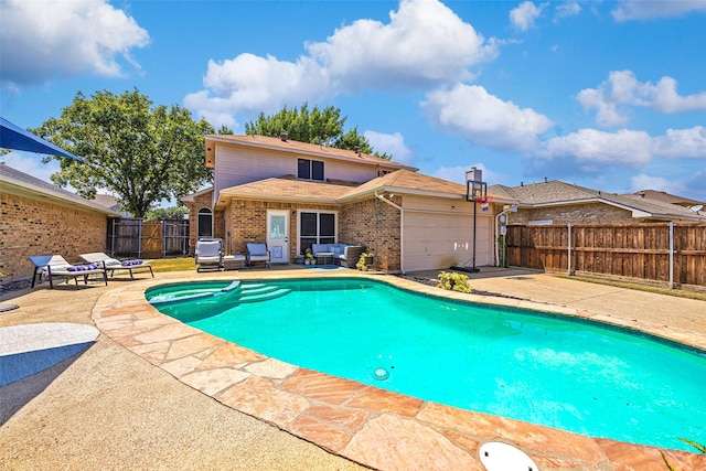 view of swimming pool featuring a pool with connected hot tub, outdoor lounge area, a gate, a patio area, and fence