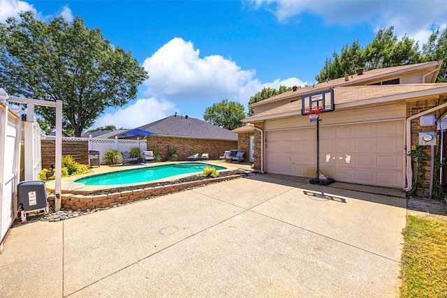 view of swimming pool featuring an outbuilding, a patio area, fence, and a fenced in pool