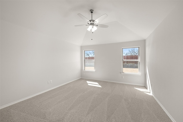 carpeted spare room featuring baseboards, lofted ceiling, and ceiling fan