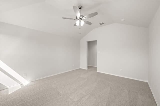 carpeted spare room featuring visible vents, ceiling fan, baseboards, and lofted ceiling