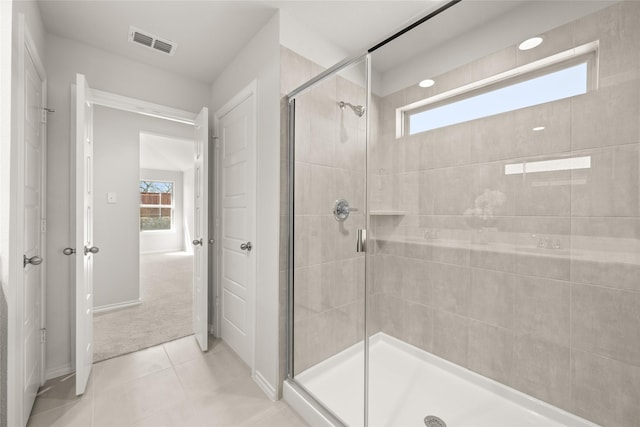 bathroom with tile patterned flooring, a shower stall, and visible vents