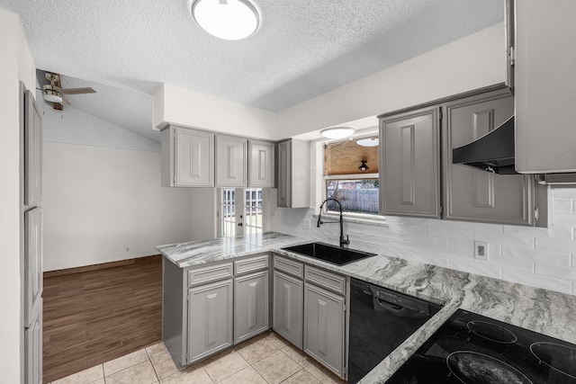 kitchen with a peninsula, a sink, and gray cabinetry