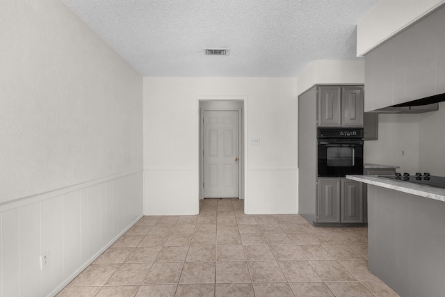 kitchen with visible vents, light countertops, wainscoting, gray cabinets, and black appliances