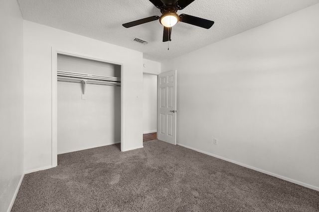 unfurnished bedroom with carpet floors, a textured ceiling, visible vents, and a closet