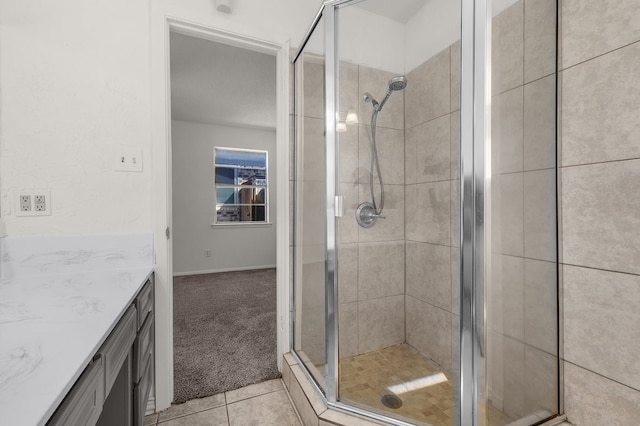 full bath with a stall shower, vanity, and tile patterned floors