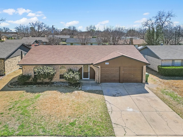 view of front of home featuring a garage, brick siding, driveway, roof with shingles, and a front yard