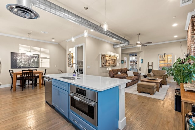 kitchen with stainless steel appliances, light countertops, visible vents, a sink, and blue cabinets