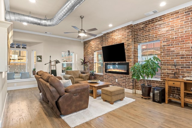 living room with visible vents, brick wall, and wood finished floors