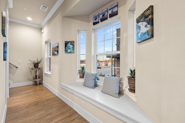 interior space featuring visible vents, baseboards, ornamental molding, wood finished floors, and recessed lighting