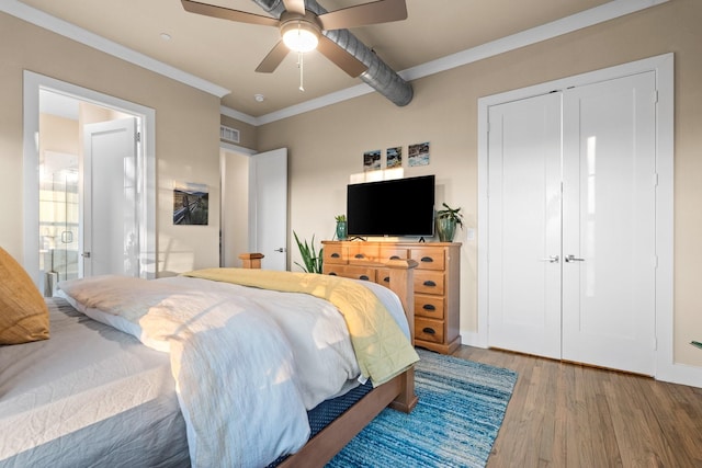 bedroom featuring wood finished floors, visible vents, baseboards, a ceiling fan, and ornamental molding