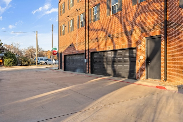 view of building exterior featuring driveway and an attached garage