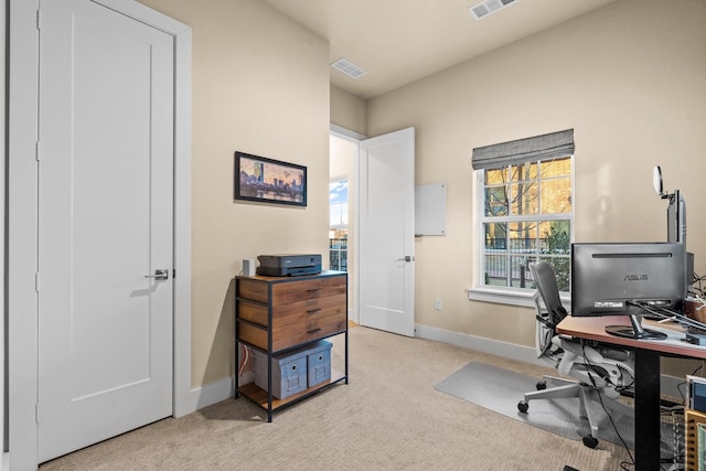 carpeted office space featuring visible vents and baseboards