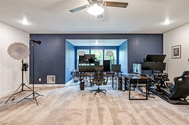 carpeted home office with a ceiling fan, visible vents, and baseboards