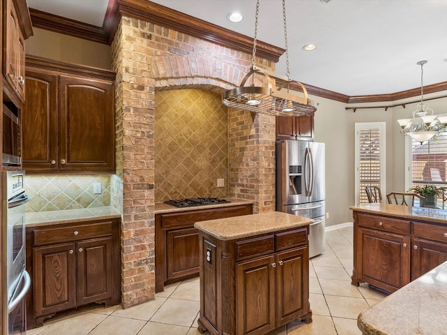 kitchen featuring stainless steel appliances, decorative light fixtures, crown molding, and decorative backsplash