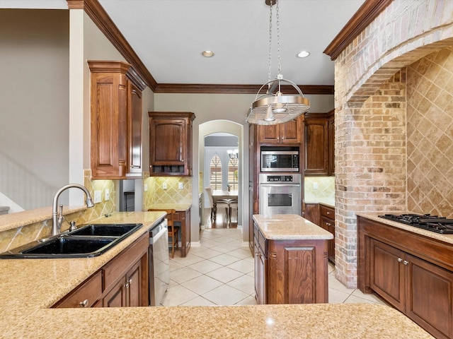 kitchen featuring tasteful backsplash, arched walkways, stainless steel appliances, crown molding, and a sink