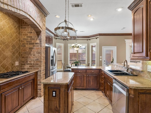 kitchen featuring appliances with stainless steel finishes, visible vents, a sink, and backsplash